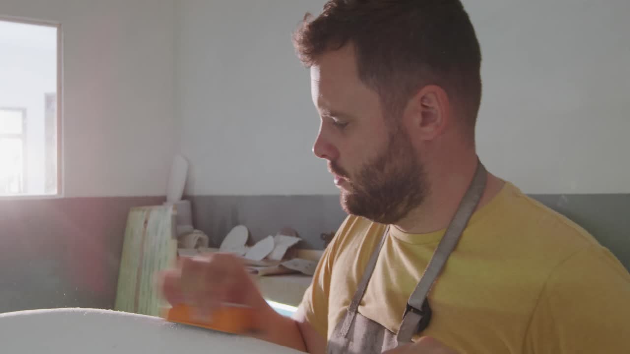 un hombre que hace tablas de surf en su taller
