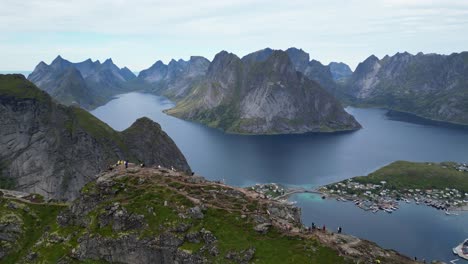 people at reinebringen hike viewpoint in reine, lofoten islands, norway, scandinavia - aerial 4k circling