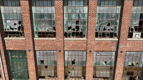 shattered glass windows in an abandoned brick building