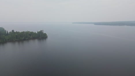 Ruhiger-Ozean-Mit-Dickichtwald-Während-Des-Nebligen-Morgens