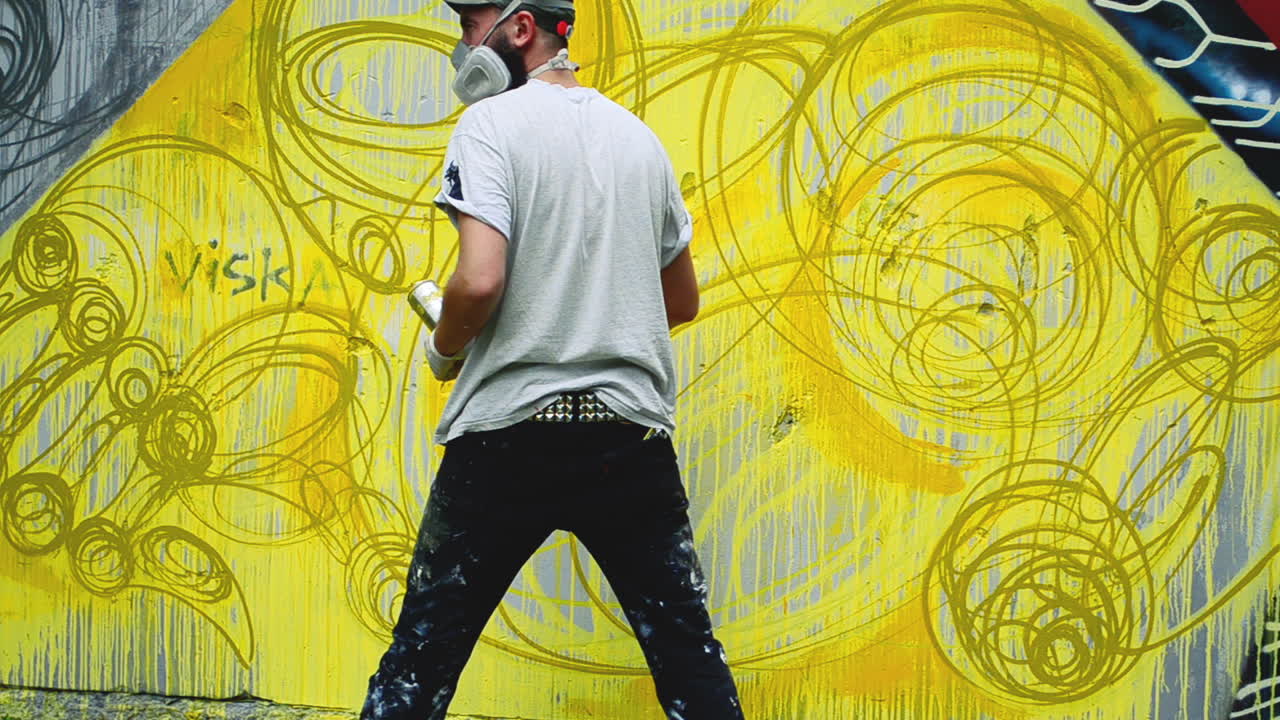 L'artista disegna graffiti su una recinzione. Disegno astratto