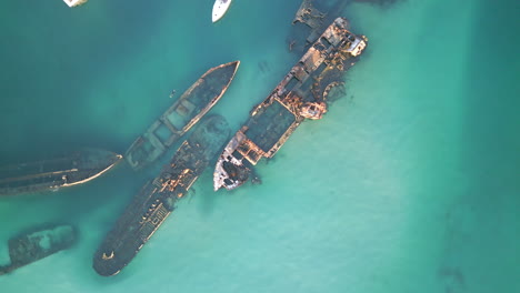 Aerial-Drone-Top-Down-Blue-Sea-Water-with-Oxidized-Sank-Ship,-Boats-Sail-Marine-Landscape