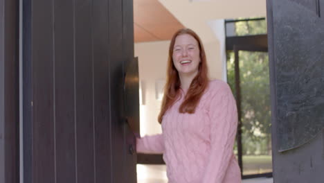 smiling woman opening door, welcoming female friends to hangout at home, copy space