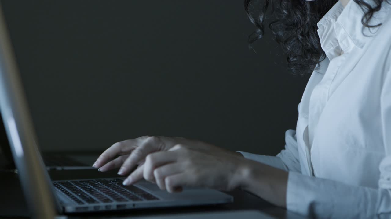 Serious young businesswoman using laptop