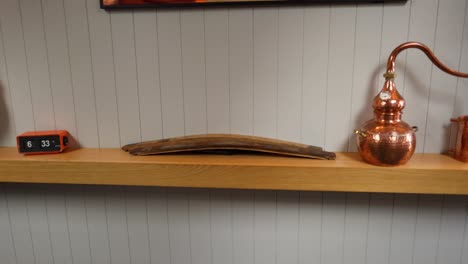 copper distiller setup on a wooden shelf