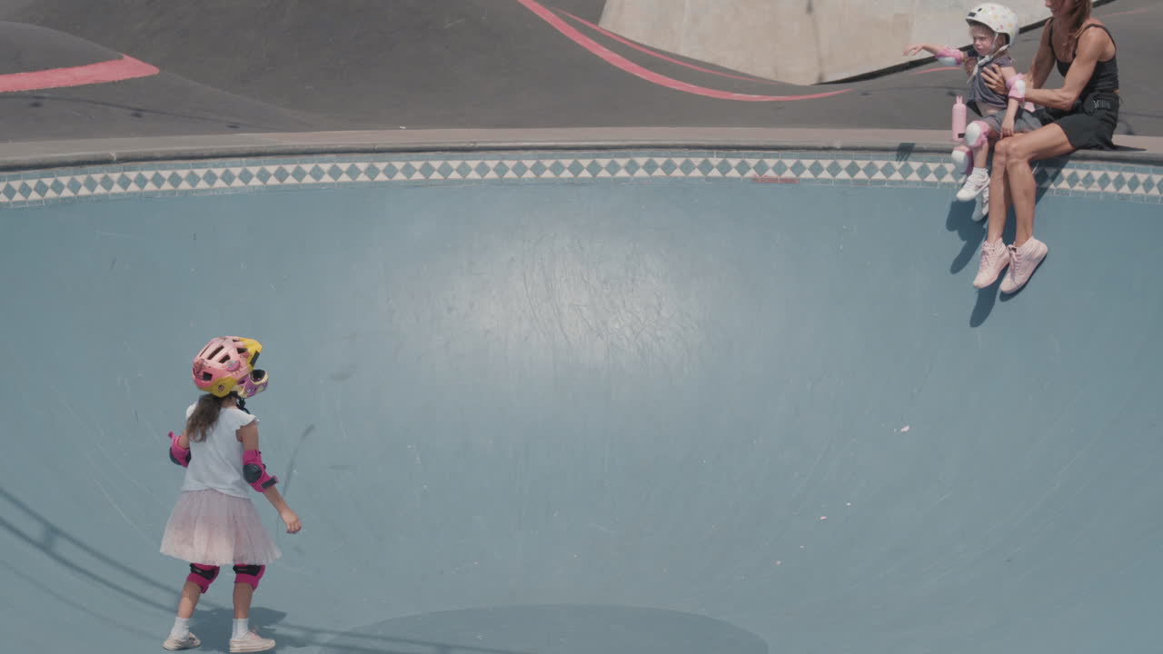 야외 스케이팅 경기장에서 아이들과 함께 있는 젊은 여성