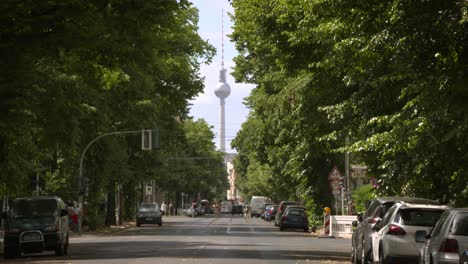 TV-Tower-of-Berlin-in-urban-summer-scenery-between-green-alley-of-trees,-Germany