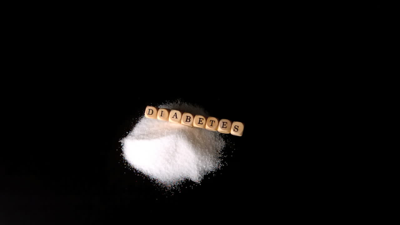 당뇨병을 표기하는 주사위가 검은색 표면에 설탕 어리 위에 떨어집니다.