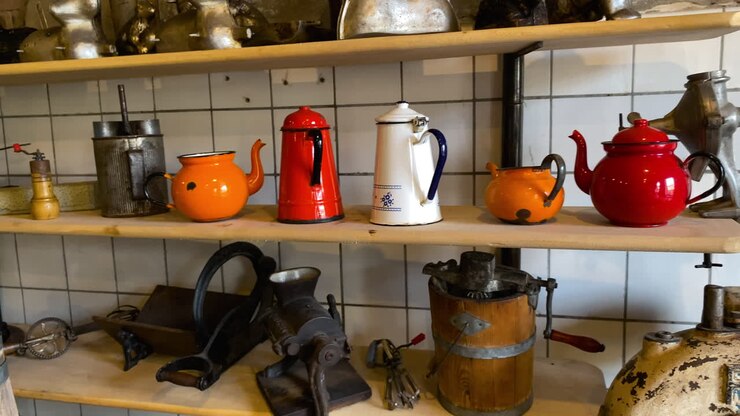 Old And Vintage Coffee Grinders With Coffee Pots Display On The Wooden Shelves