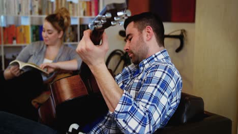 Mann-Spielt-Gitarre,-Während-Frau-Buch-Liest