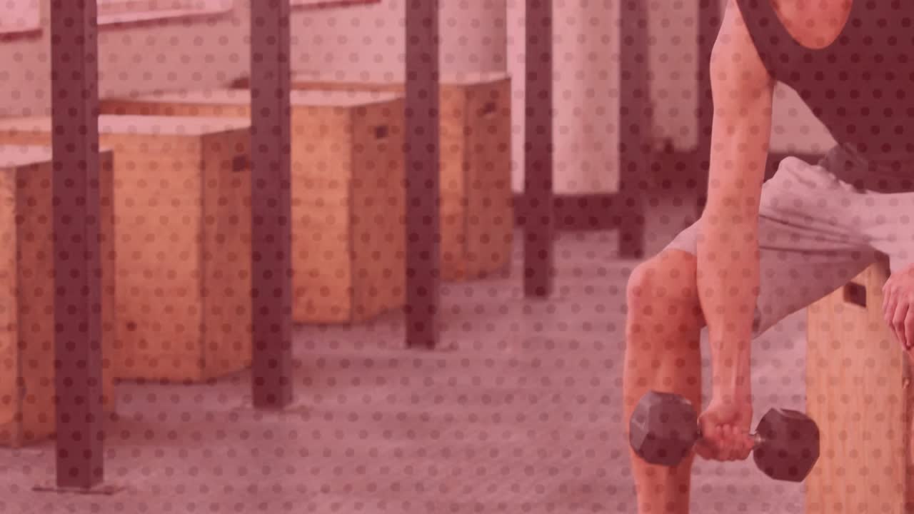 Man reaching dumbbell near foot, curling one-arm dumbbell while bracing elbow on thigh for fitness