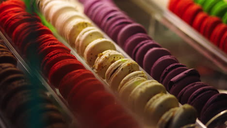 Surtido-De-Macarons-Franceses-De-Colores-Brillantes-En-Una-Vitrina,-Enfocando-La-Bandeja-Derecha