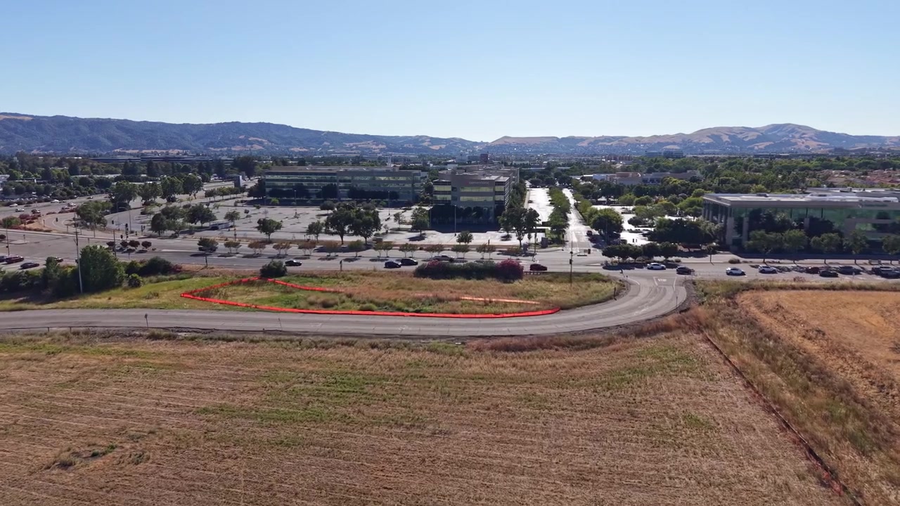 Dronevideo glider over solbeskinnede Dublin, Californien, og fanger moderne kontorbygninger, brede veje, gyldne græsmarker og en naturskøn bjergkulisse i klare blå dagslys luftoptagelser.