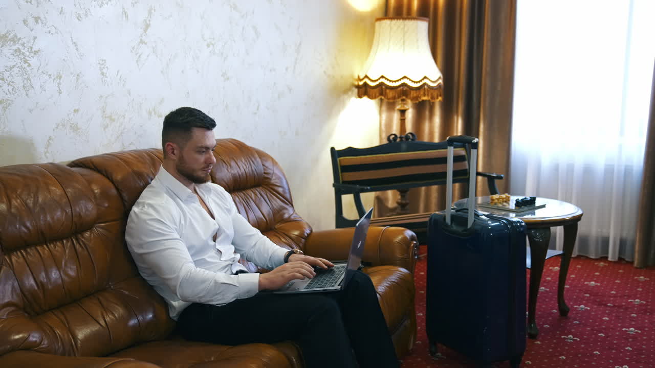 Businessman working in hotel. Young businessman working with laptop in hotel room