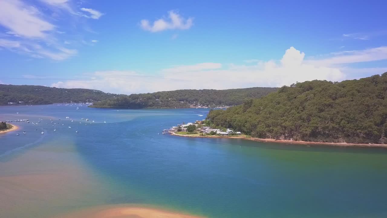 Aerial view of tropical beach with turquoise blue water, white sandy beach, shallow water and national park forest island in a sunny day.