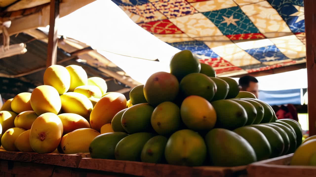 Mano che seleziona manghi freschi in una vivace bancarella del mercato