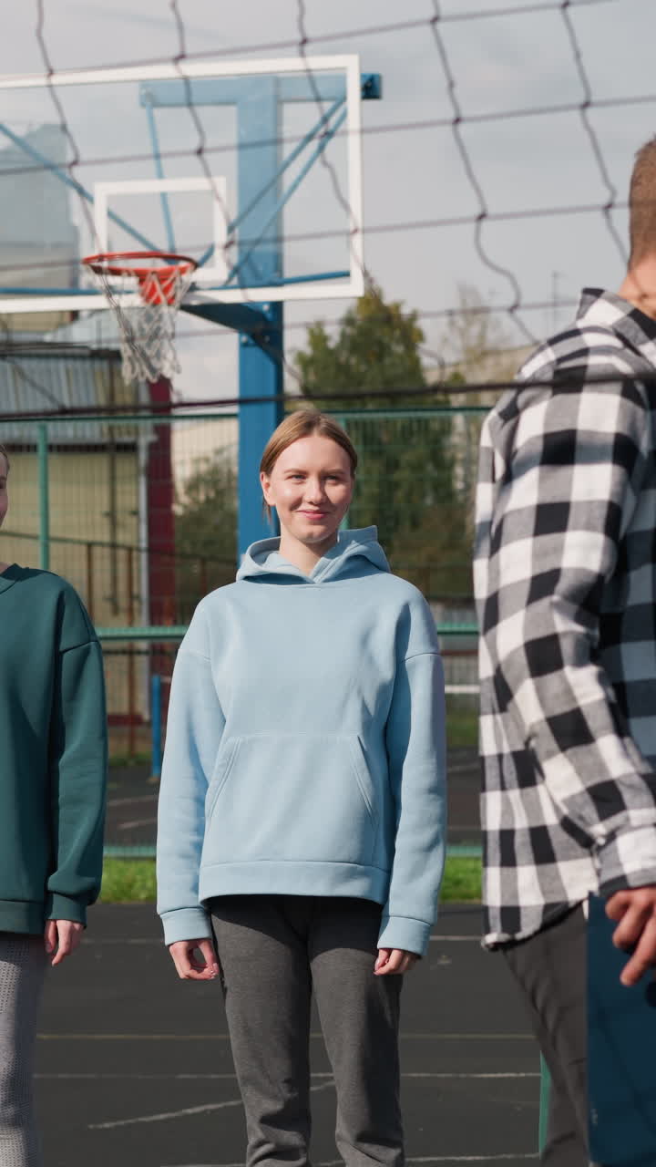 los jugadores de voleibol practican sus habilidades con el entrenador en la cancha al aire libre, de pie con confianza y sonriendo, la sesión de entrenamiento tiene lugar bajo un cielo despejado, rodeado de árboles y edificios residenciales