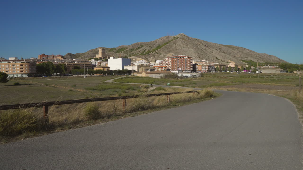 A zigzag street near the town of a Castle and hills.