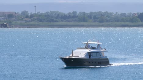 A-luxury-yacht-sailing-near-the-coast-of-Ortigia,-Siracusa,-Sicily