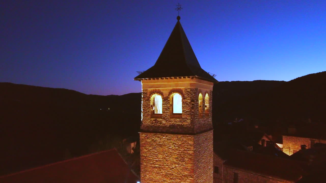volando sobre una iglesia en un pueblo de montaña en los pirineos españoles al atardecer