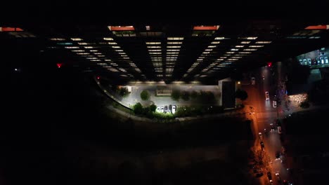 vista aérea nocturna del edificio de la ciudad con estacionamiento