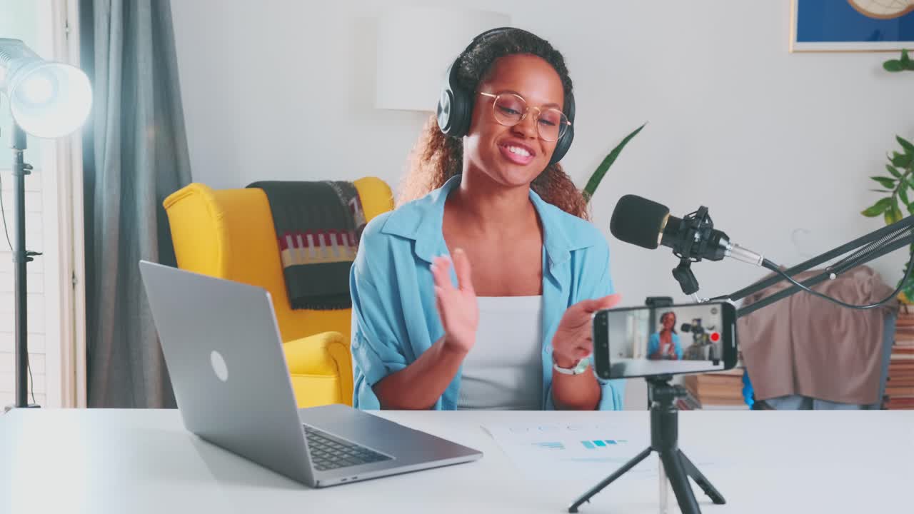 Young african american woman financial blogger records video sits at table