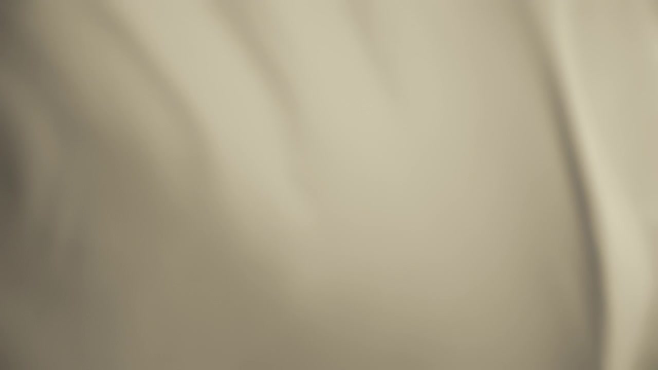 Silky pastel light beige fabric waving in the wind