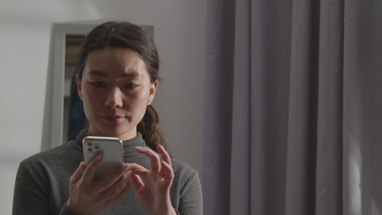 직장 제안을 확인하는 문자 메시지를 받는 집에서 기뻐하는 젊은 여성