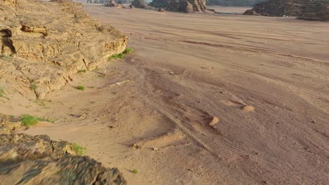 mujer con vestido rojo de pie en una roca por encima del desierto de wadi rum en aqaba, jordania