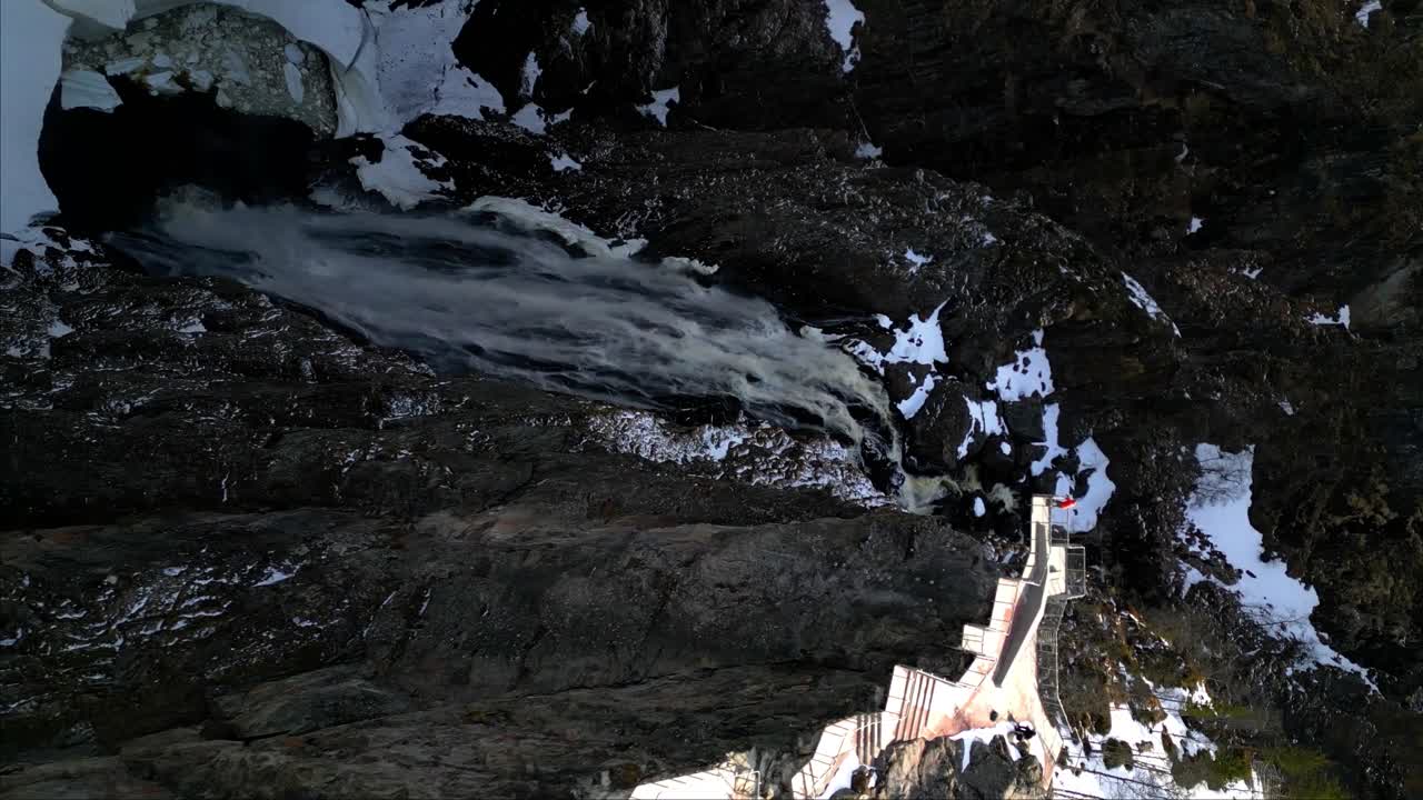 Vertical shot of photographer captured the beauty of Voringfossen waterfall during winter in Vestland county, Norway. The waterfall is 182 meters high in Norway.