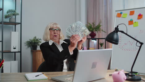 mujer contable de negocios celebrando el éxito del negocio bailando con una pila de dinero dólares en efectivo