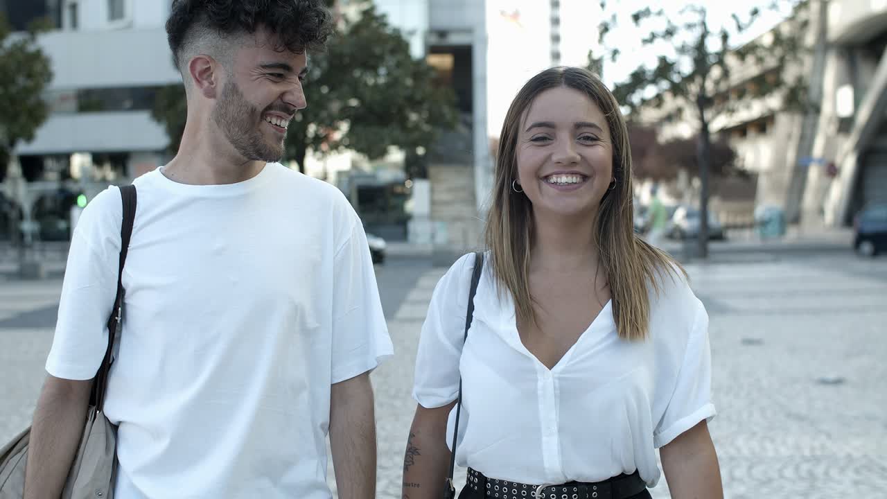 Vista frontale di una felice giovane coppia che cammina per strada