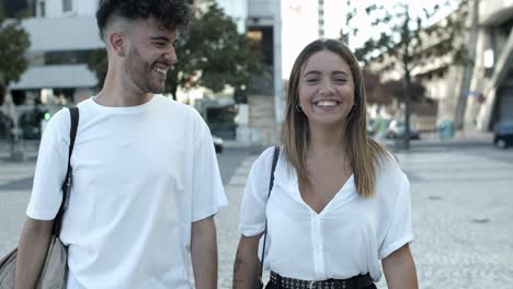 vista frontal de una feliz pareja joven caminando por la calle