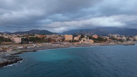 genoa coastline with buildings against hills, cloudy skies, aerial view