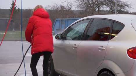 slow motion shot of woman washing her car during winter