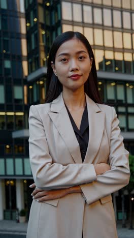 young businesswoman stands confidently with her arms crossed in front of a modern office building, exuding professionalism and success in the corporate world