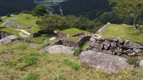 slow panning shot showing different sites within takeda castle, japan