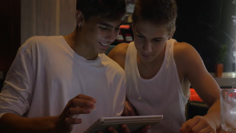 Two-teen-friends-with-tablet-computer-in-cafe