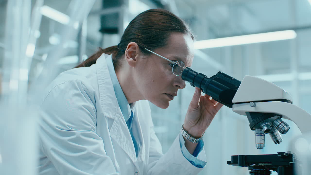 Scienziata Che Conduce Ricerche Dettagliate con un Microscopio da Laboratorio