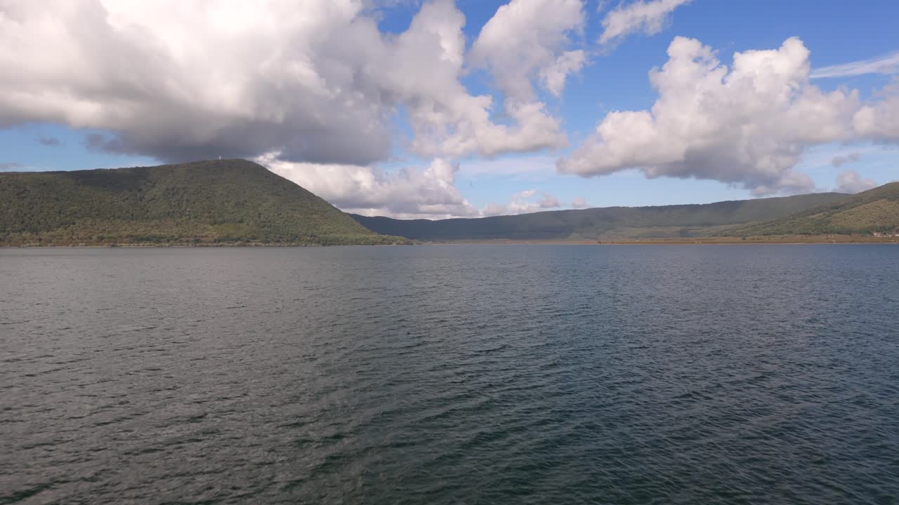 이탈리아의 비코 호수 (vico lake) 에 드론이 아져 나와 선박 위에서 해가 지고 있다.