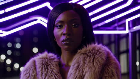 woman in fur coat against purple neon lights