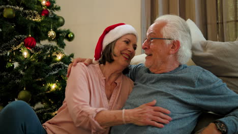 senior couple embracing joyfully by christmas tree, celebrating holiday together
