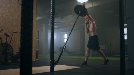 Slow-motion:-Man-doing-Single-Arm-Landmine-Squat-to-Press-exercise.-Young-man-lifting-barbell-with-light-weights-at-gym