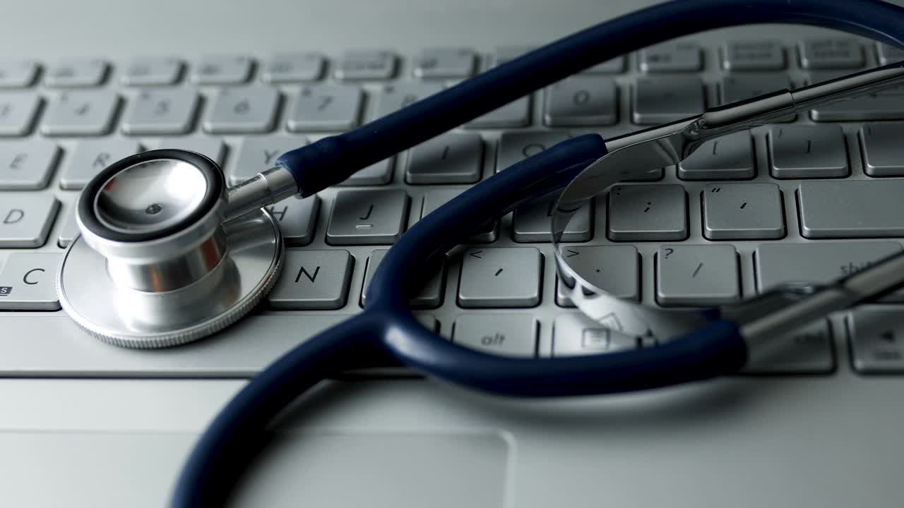estetoscopio en el teclado de la computadora portátil. 4k dolly shot