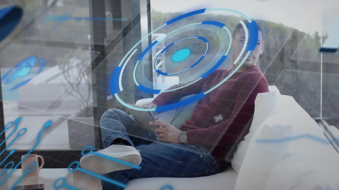 Mid-adult man tapping tablet on sofa near glass doors, starting blue HUD animating for tech demo