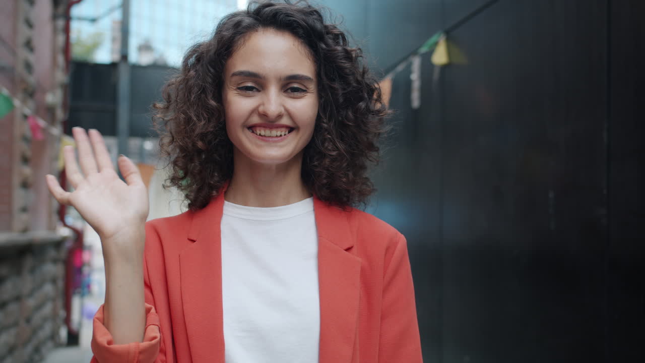 Smiling Woman Waving in City Street