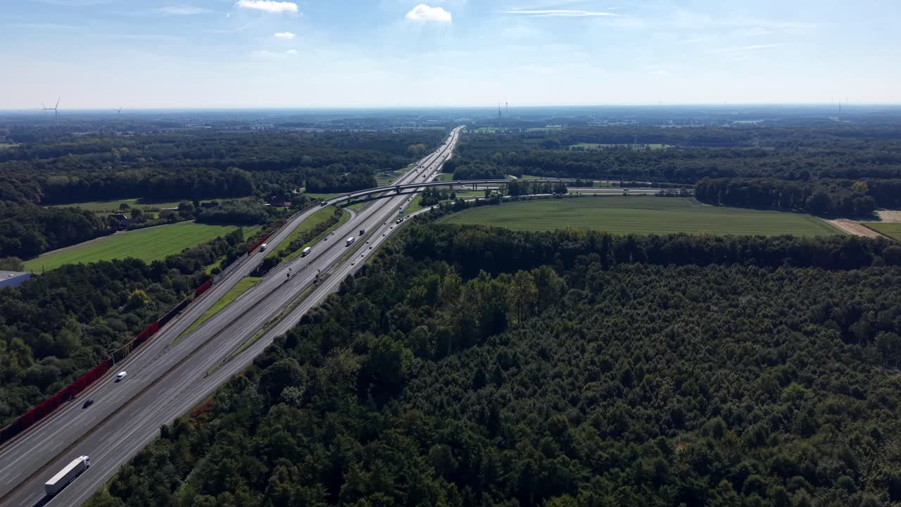 Traffic on American highway in rural forest area at sunny day. Autumn Season with cars and trucks on interstate junction. Aerial dolly wide shot