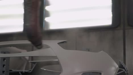 pintura por pulverización en la línea de producción en el coche vehículo blanco en la fábrica por máquinas automatizadas