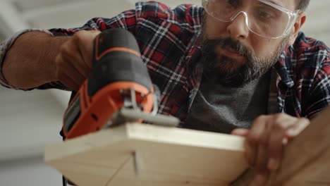 video of carpenter sawing wood with an electric jigsaw