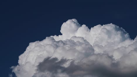 dramatic cumulus clouds against a dark blue sky